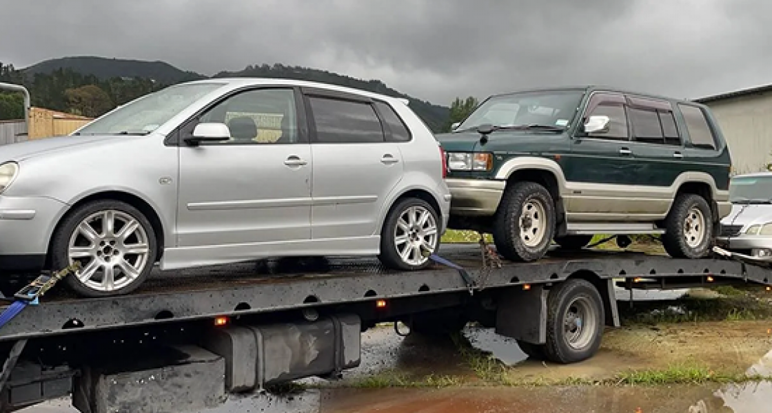 Tow truck transporting three scrap cars for removal in whanganui